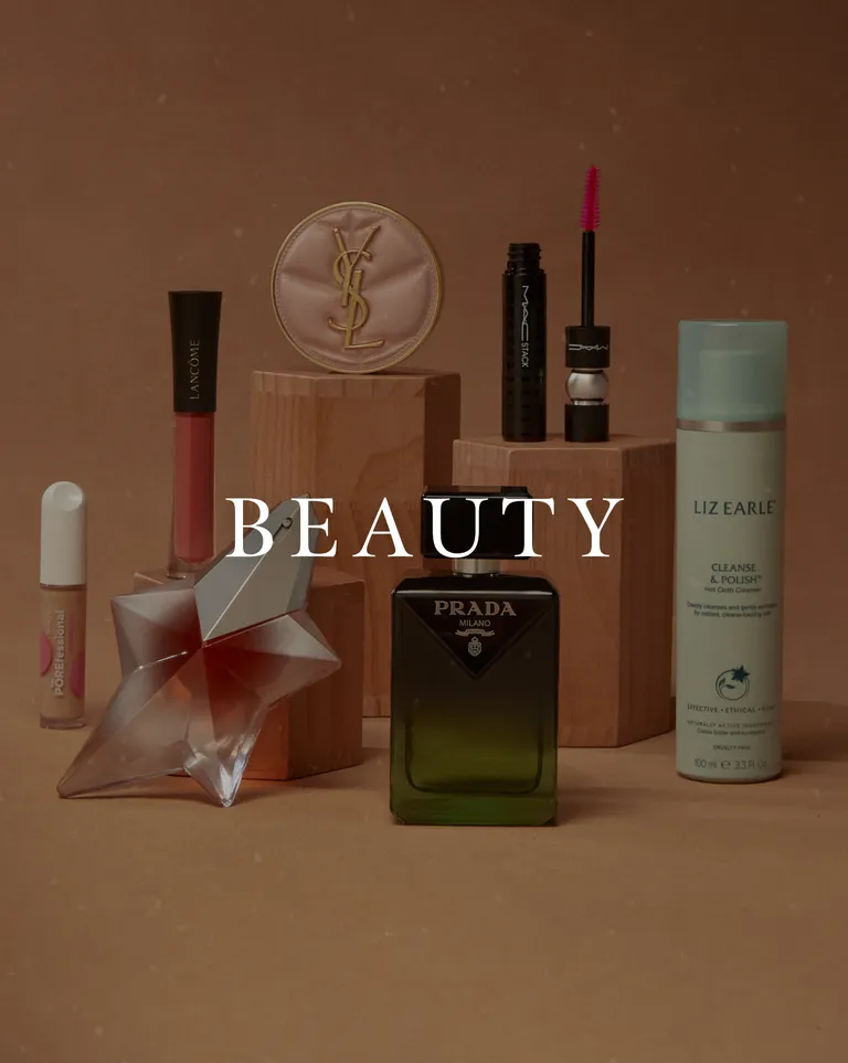 Beauty products collection featuring Prada, YSL, Lancôme, MAC, Liz Earle, and POREfessional on wooden pedestals
